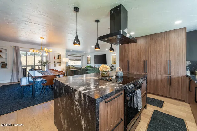 a kitchen with stainless steel appliances a sink a stove and a wooden floors