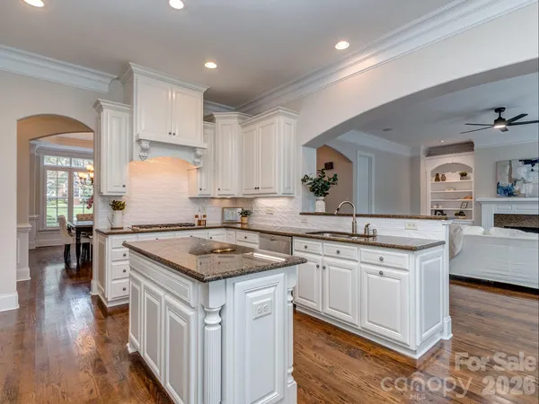 a kitchen with stainless steel appliances granite countertop a sink stove and wooden floor