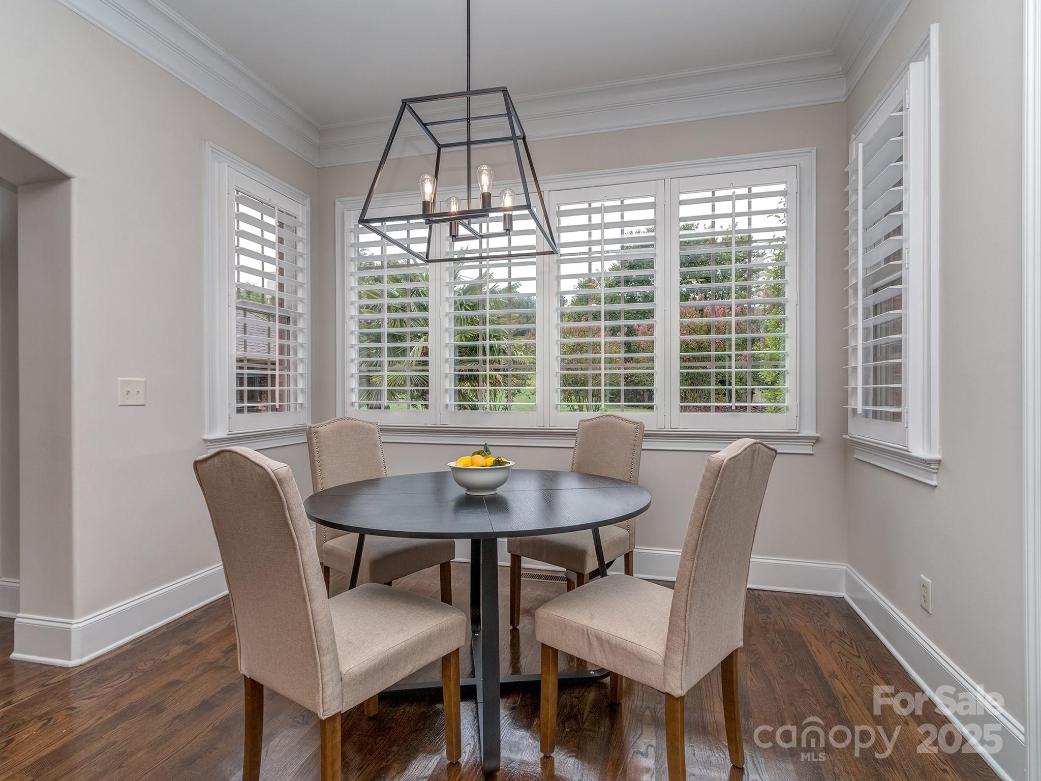 8208 Wingard Road Waxhaw, NC 28173 - Photo 16 of 41 a dining room with furniture a chandelier and wooden floor