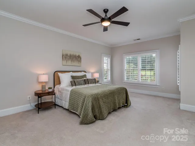 a spacious bedroom with a bed a window and a chandelier