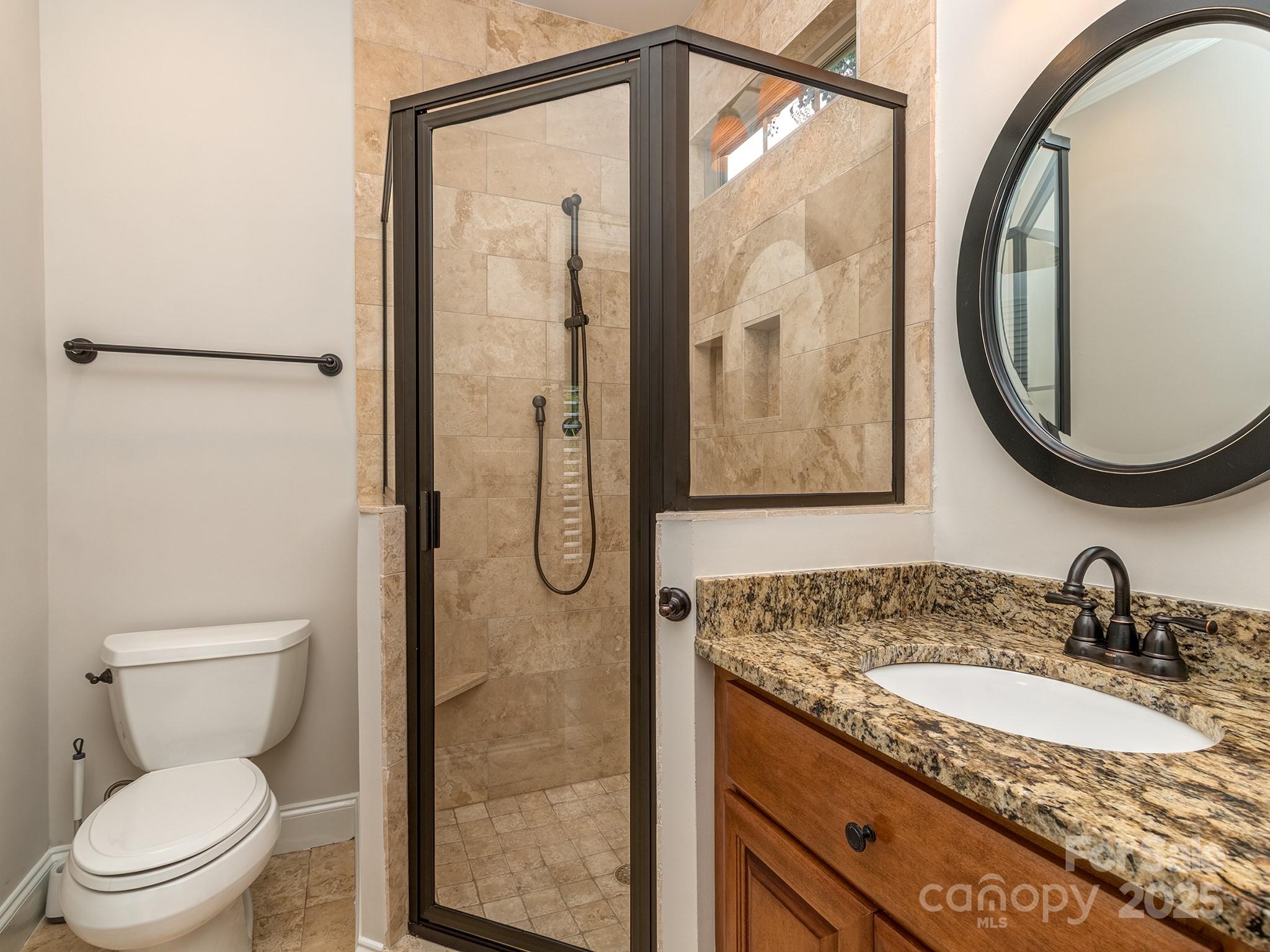 8208 Wingard Road Waxhaw, NC 28173 - Photo 33 of 41 a bathroom with a granite countertop sink toilet and a mirror