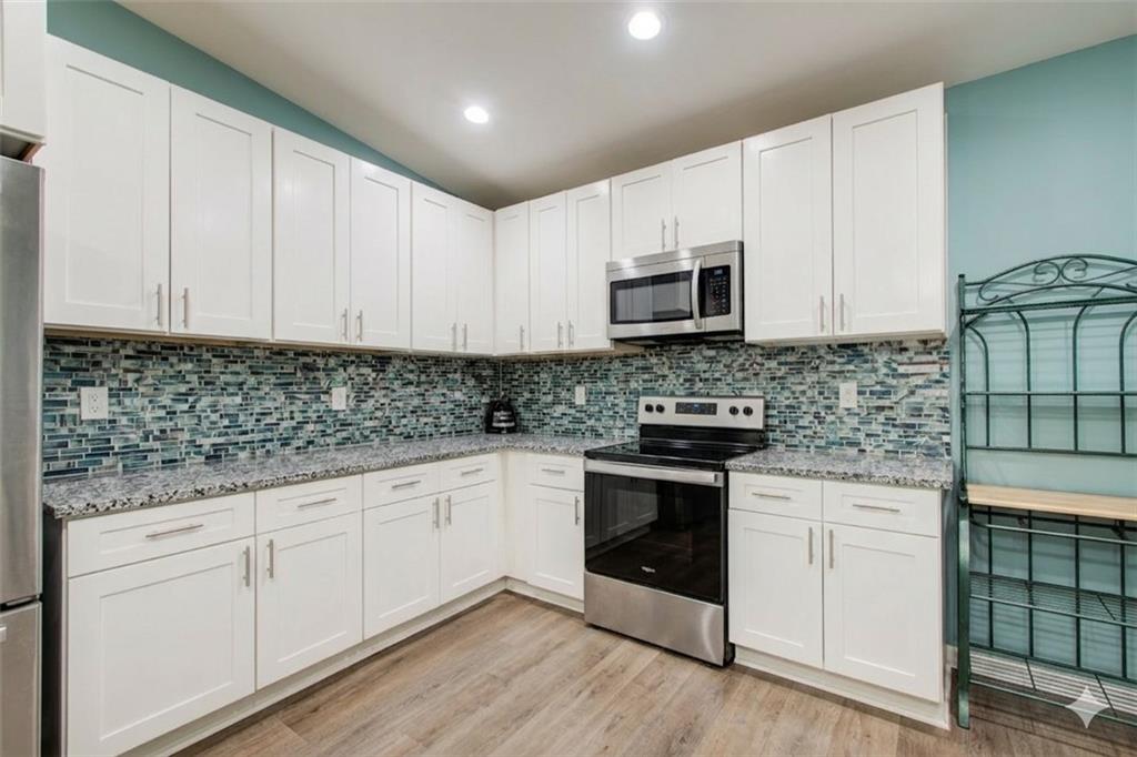 2619 Old Toney Road Ellenwood, GA 30294 - Photo 12 of 32 a kitchen with granite countertop white cabinets and white appliances