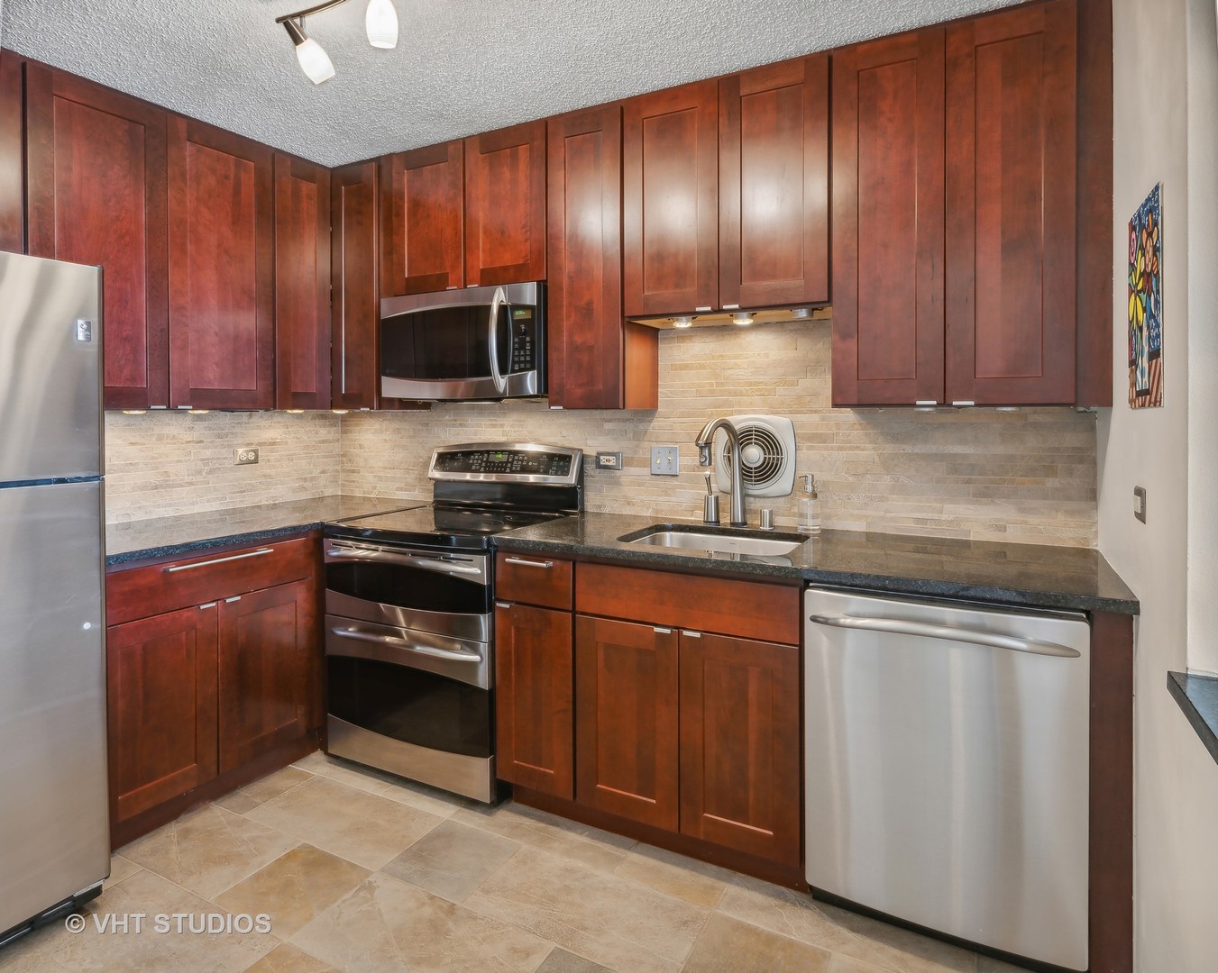 111 West Maple Street, Unit 3011 Chicago, IL 60610 - Photo 3 of 11 a kitchen with granite countertop wooden cabinets and stainless steel appliances