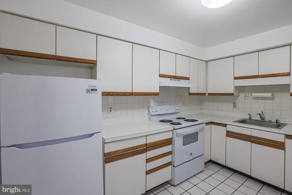 a kitchen with white cabinets and white appliances