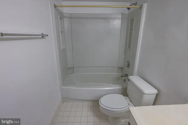 a white toilet sitting next to a bath tub