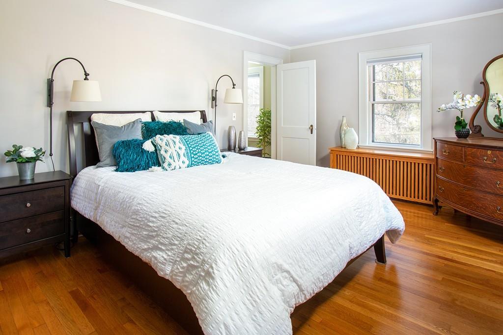 98 Clark Road Brookline, MA 02445 - Photo 7 of 12 a bedroom with a bed and dresser with mirror