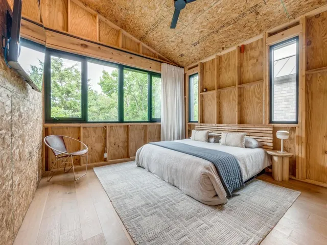 a bedroom with a bed and a large window