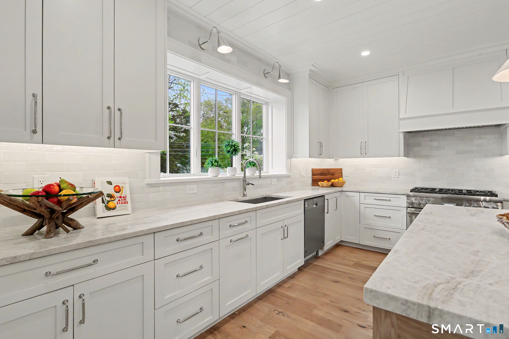 96 Clinton Street Fairfield, CT 06824 - Photo 5 of 34 a kitchen with a sink stove and cabinets