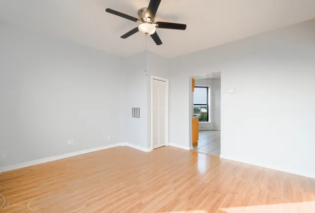 a view of empty room with wooden floor