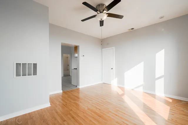 a view of an empty room with wooden floor