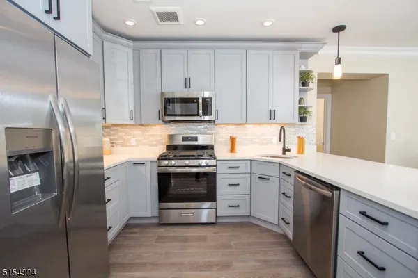 a kitchen with stainless steel appliances a refrigerator sink and microwave