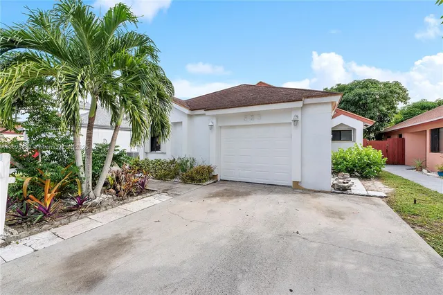a view of a house with a yard and potted plants