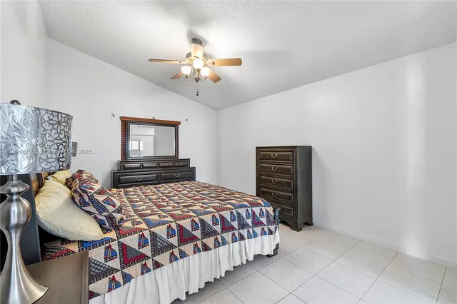 a bedroom with a bed and dresser with mirror