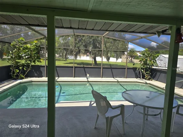 a view of a house with a big yard and large trees