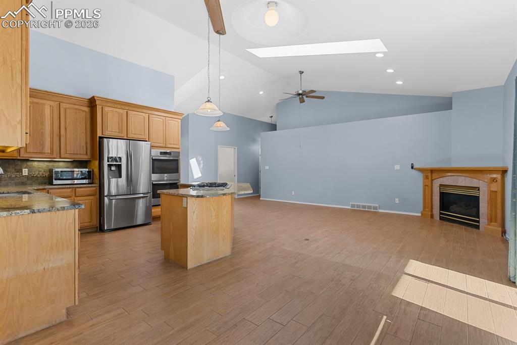 505 Cimarron Road Monument, CO 80132 - Photo 21 of 50 Living room with walkout to the easy maintenance deck and a gas fireplace