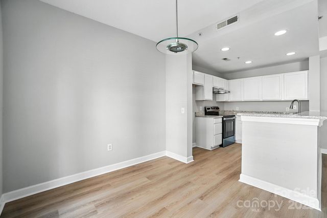 a kitchen with a refrigerator a stove top oven and white walls