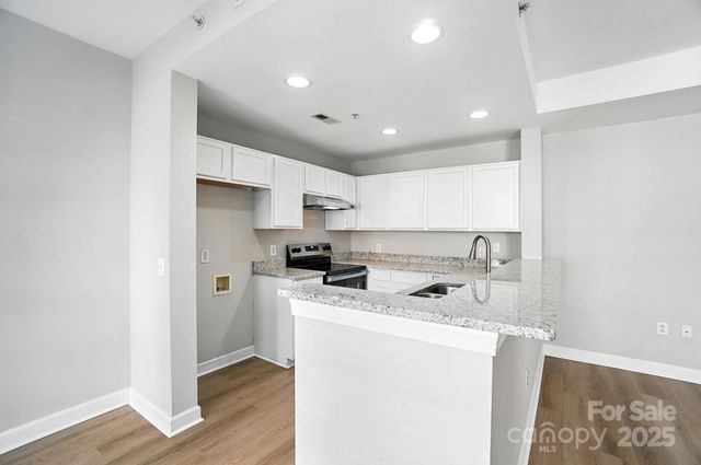 a kitchen with stainless steel appliances a sink a stove a refrigerator and cabinets