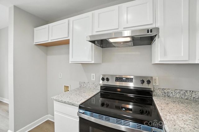 a stove top oven sitting inside of a kitchen