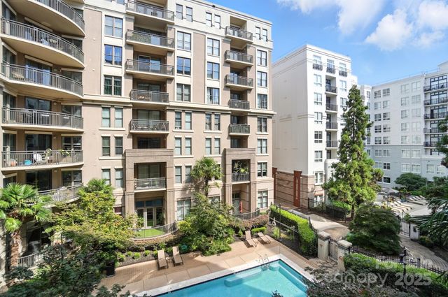 a view of tall building with a garden and plants