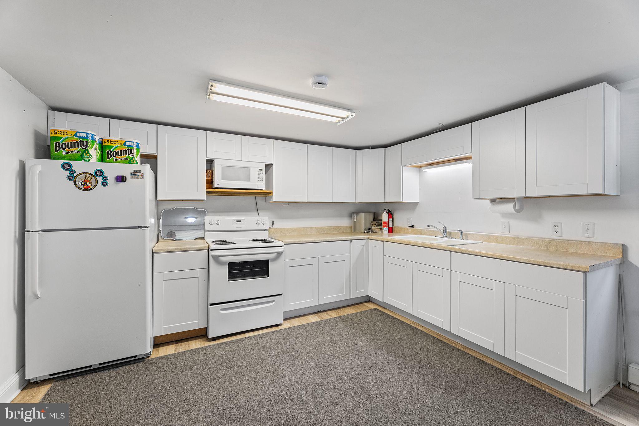 11920 Back Creek Road Bishopville, MD 21813 - Photo 12 of 38 a kitchen with white cabinets and white appliances