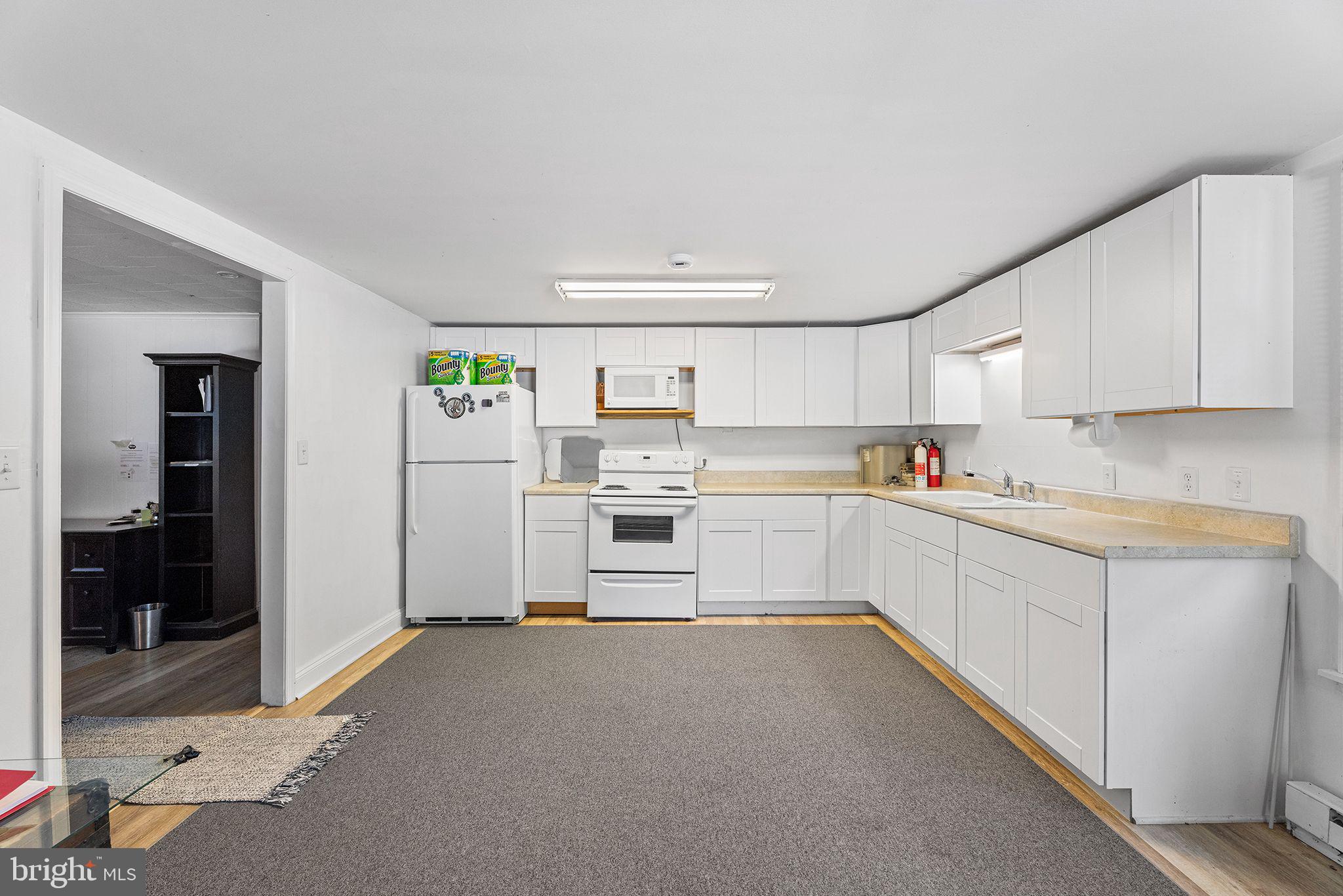 11920 Back Creek Road Bishopville, MD 21813 - Photo 13 of 38 a kitchen with white cabinets and white appliances