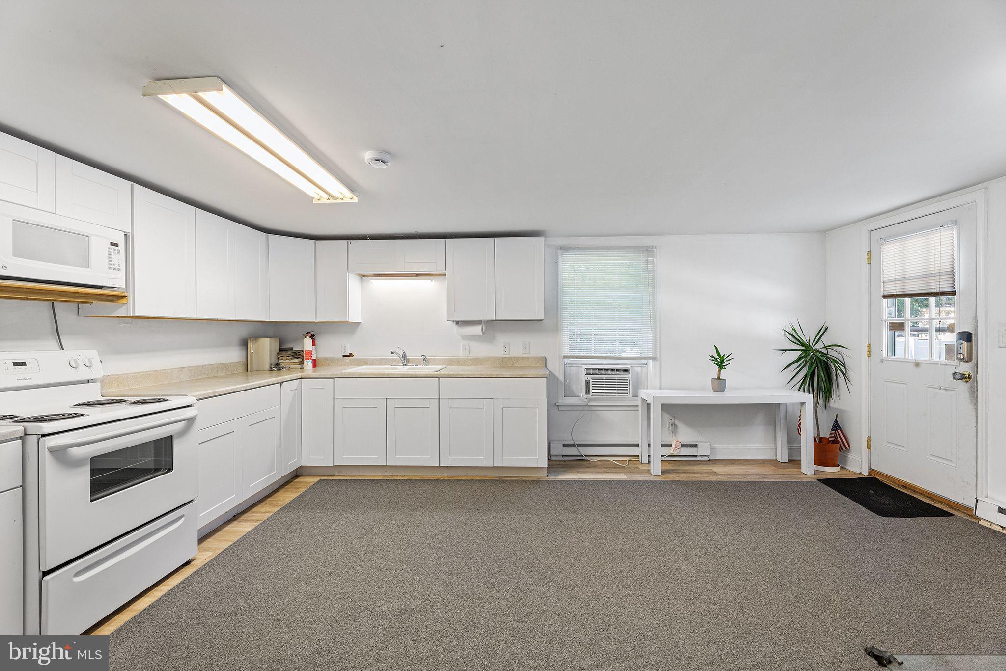 11920 Back Creek Road Bishopville, MD 21813 - Photo 14 of 38 a kitchen with white cabinets and white appliances