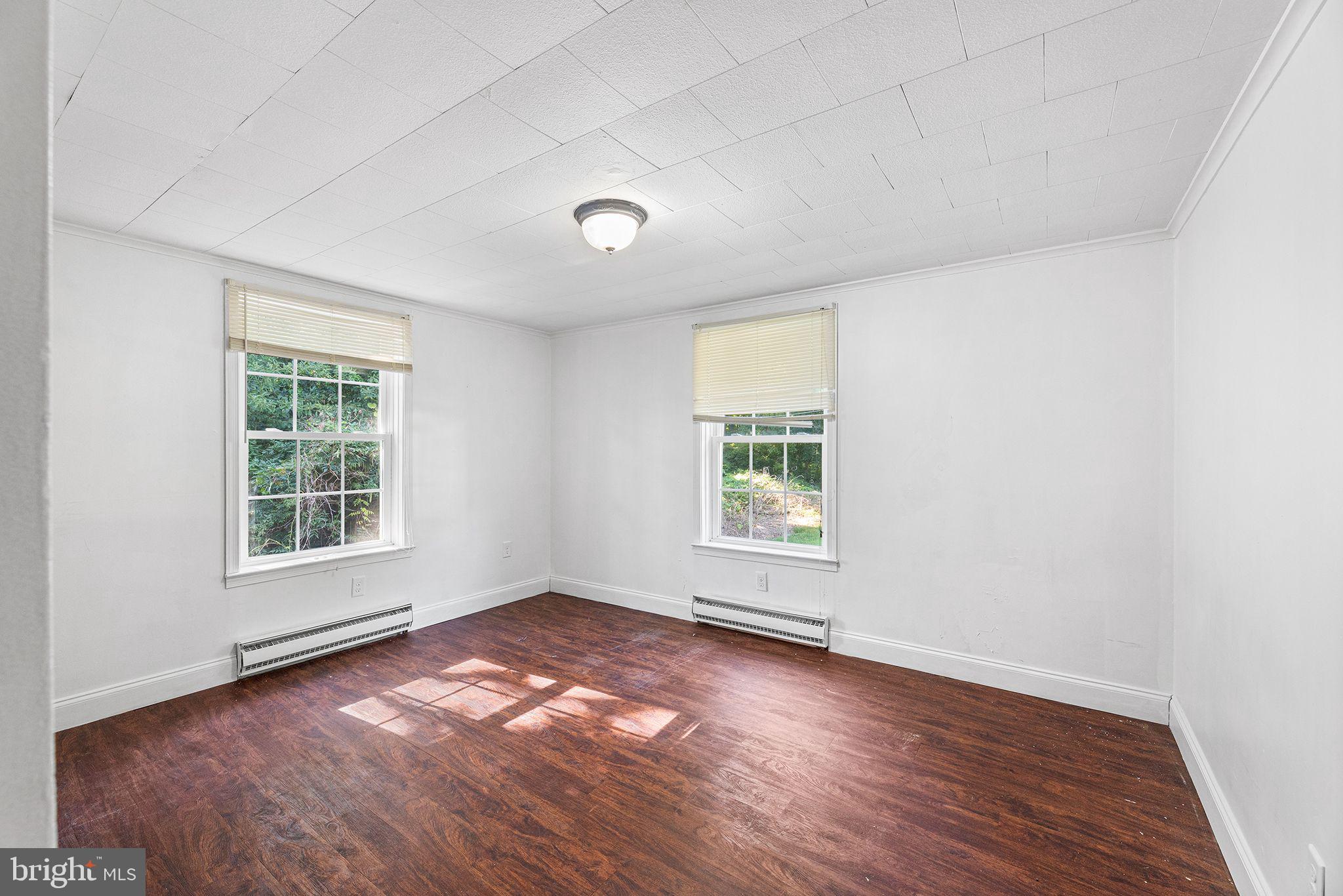 11920 Back Creek Road Bishopville, MD 21813 - Photo 23 of 38 an empty room with wooden floor and windows