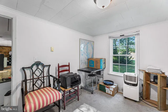 a view of a workspace with furniture and a window