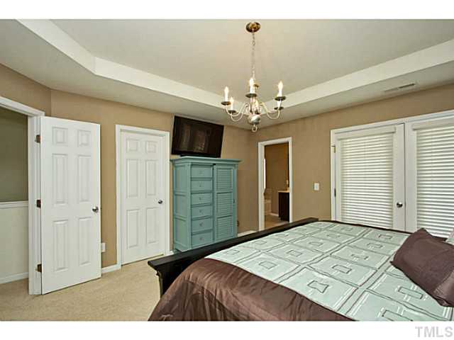 1802 Affirmed Way Cary, NC 27519 - Photo 10 of 24 a bedroom with a bed and a chandelier