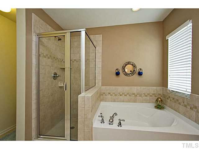 1802 Affirmed Way Cary, NC 27519 - Photo 11 of 24 a bathroom with a bathtub and a shower