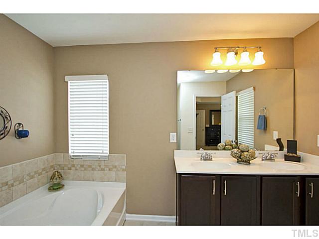 1802 Affirmed Way Cary, NC 27519 - Photo 12 of 24 a bathroom with a sink mirror and a bathtub