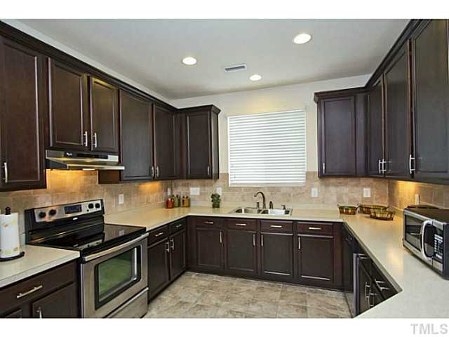 1802 Affirmed Way Cary, NC 27519 - Photo 4 of 24 a kitchen with a sink a stove and cabinets