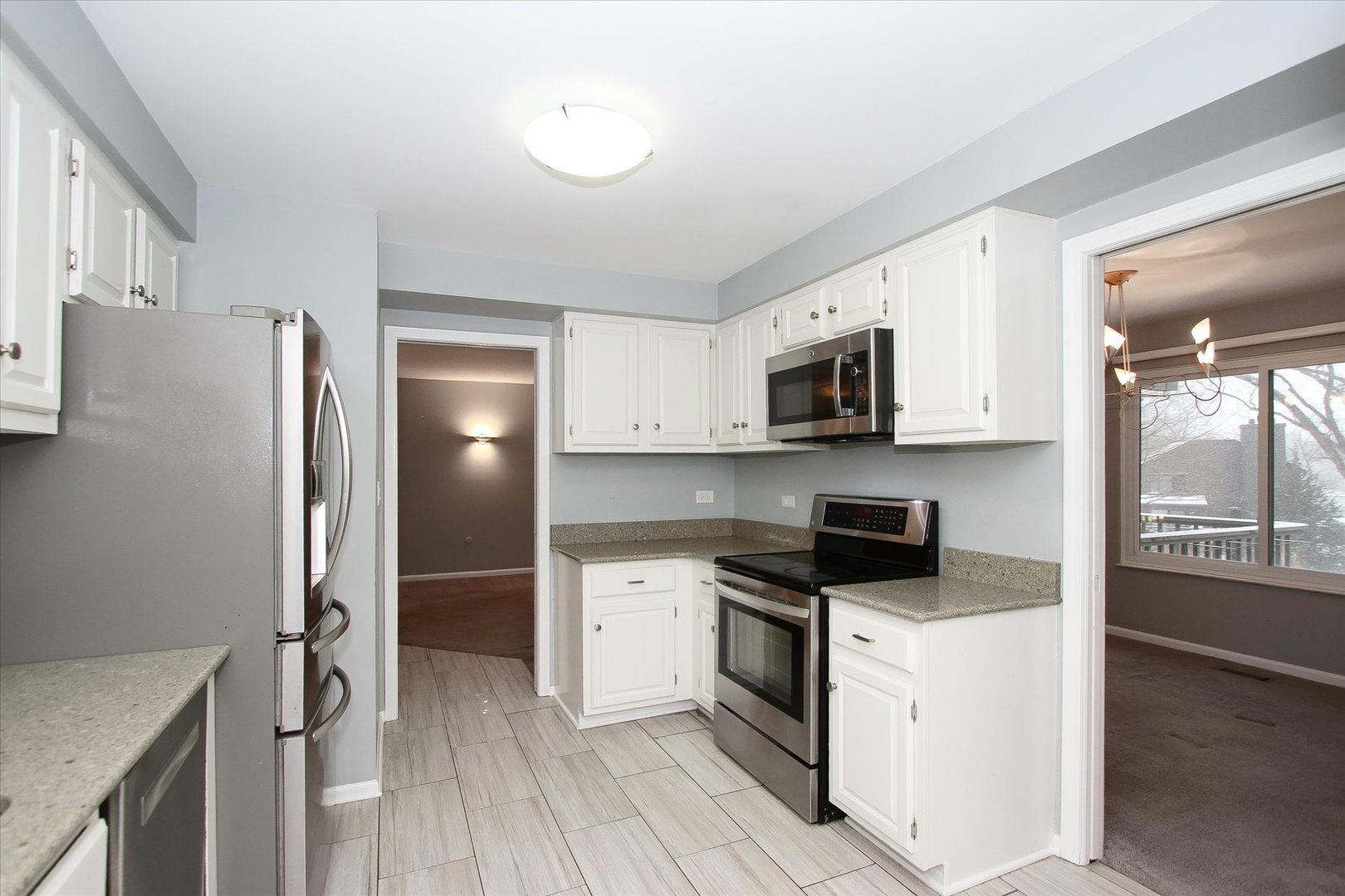 299 Mallard Point, Unit D Lake Barrington, IL 60010 - Photo 8 of 30 a kitchen with stainless steel appliances granite countertop a refrigerator stove and sink