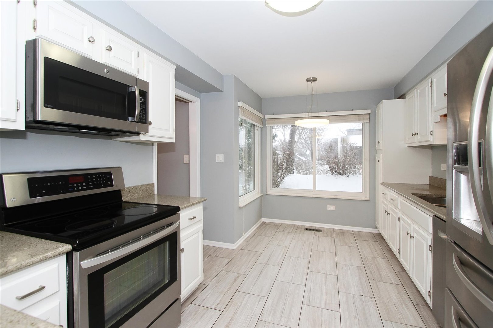 299 Mallard Point, Unit D Lake Barrington, IL 60010 - Photo 9 of 30 a kitchen with stainless steel appliances a stove microwave and sink