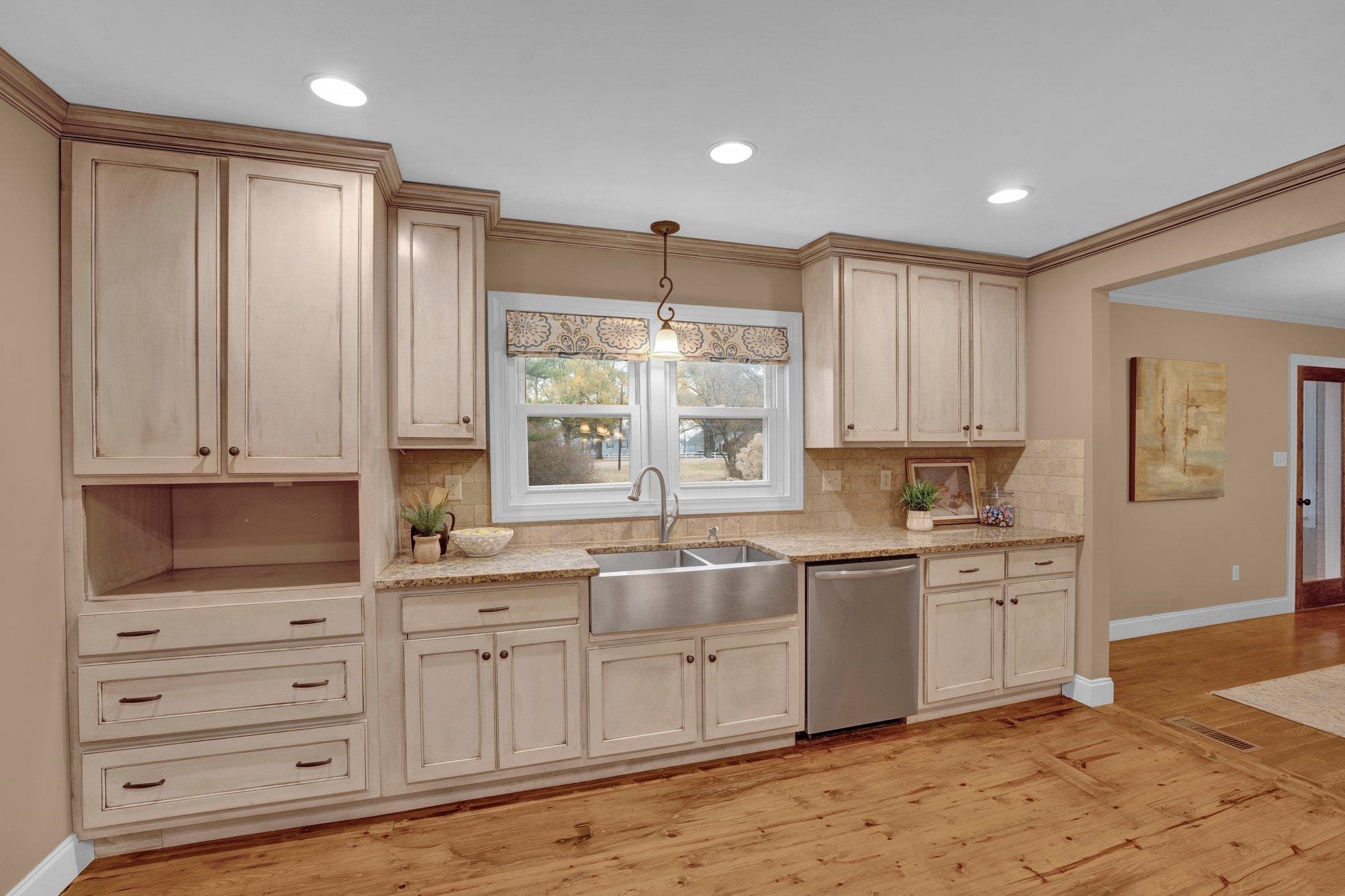 1060 Beaver Creek Road Brighton, TN 38011 - Photo 13 of 40 Kitchen with decorative backsplash, light wood-type flooring, stainless steel dishwasher, crown molding, and sink