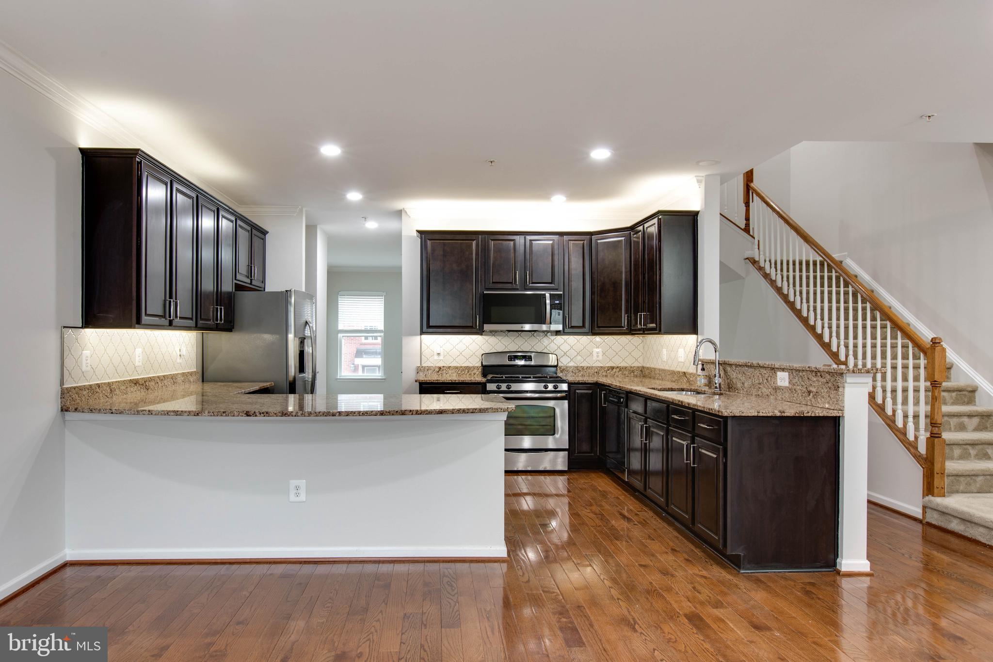 2706 Amber Crest Road Hanover, MD 21076 - Photo 15 of 44 a kitchen with stainless steel appliances granite countertop a stove top oven a sink and a refrigerator