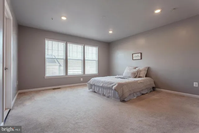 a spacious bedroom with a bed and a window