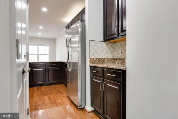 a kitchen with stainless steel appliances granite countertop a refrigerator and a stove