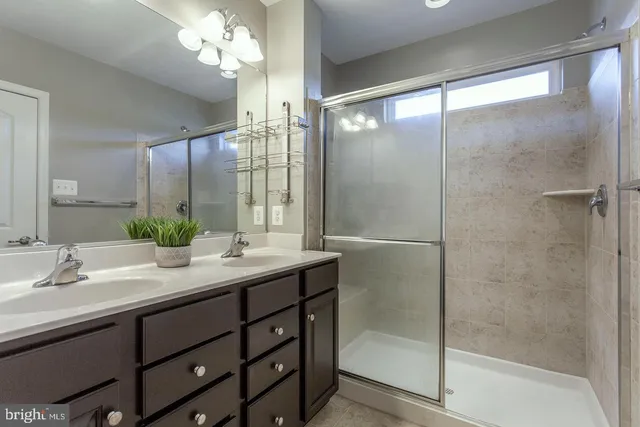 a bathroom with a double vanity sink mirror and shower