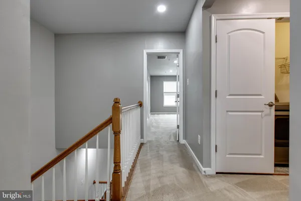 a view of a hallway with wooden floor and entryway