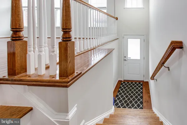 a view of staircase with wooden floor and a rug