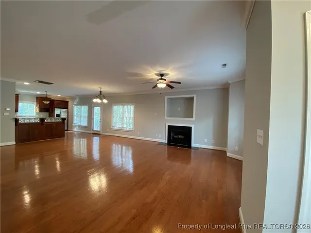 a view of a livingroom with a furniture wooden floor and a kitchen