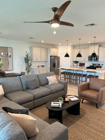 a living room with furniture a rug and kitchen view
