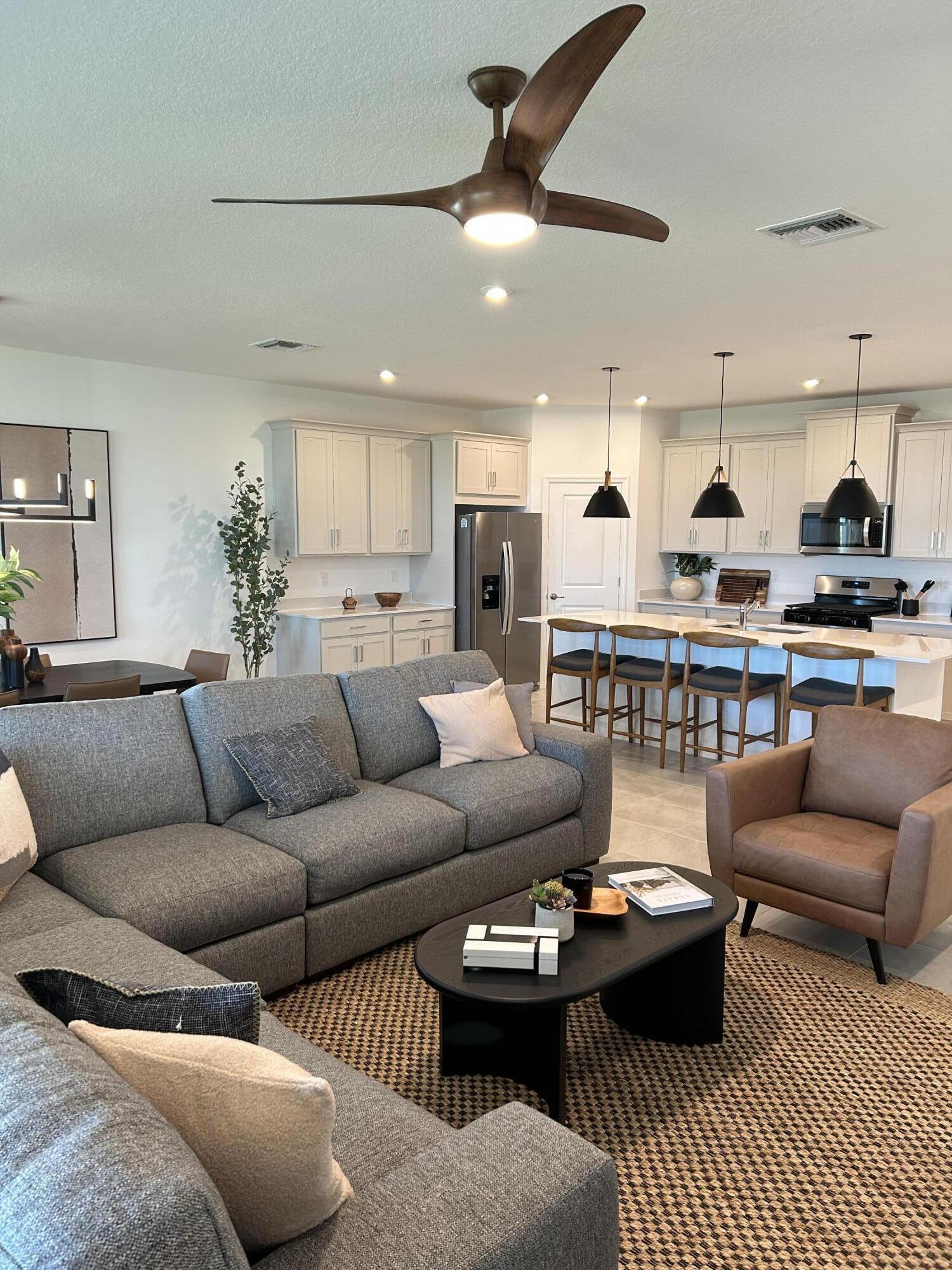 a living room with furniture a rug and kitchen view