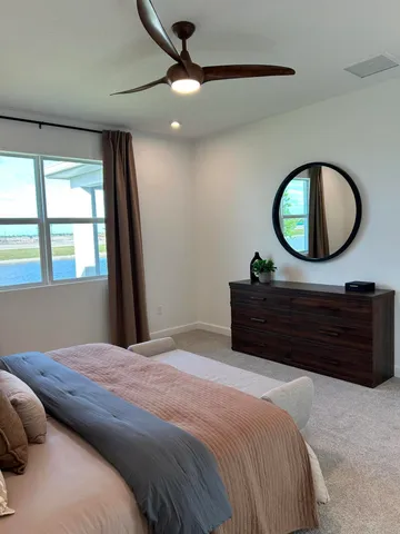 a bedroom with a large bed and a large mirror