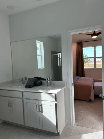 a en suite bathroom with a granite countertop sink and a mirror
