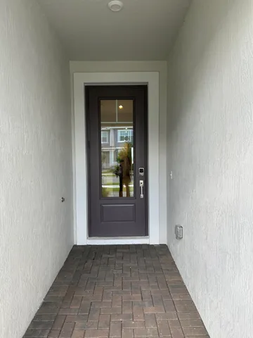 a view of a hallway with a glass door and a window