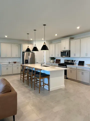 a open kitchen that has a lot of cabinets a island and appliances in it