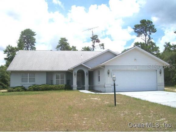 17285 Southwest 36th Ave Road Ocala, FL 34473 - Photo 1 of 1 a view of a white house next to a yard with potted plants