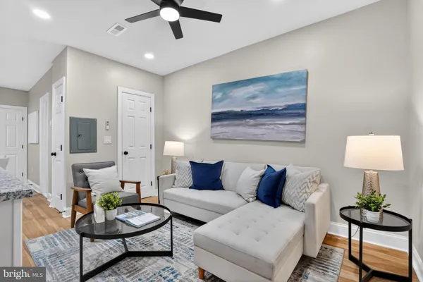 a living room with furniture and a wooden floor
